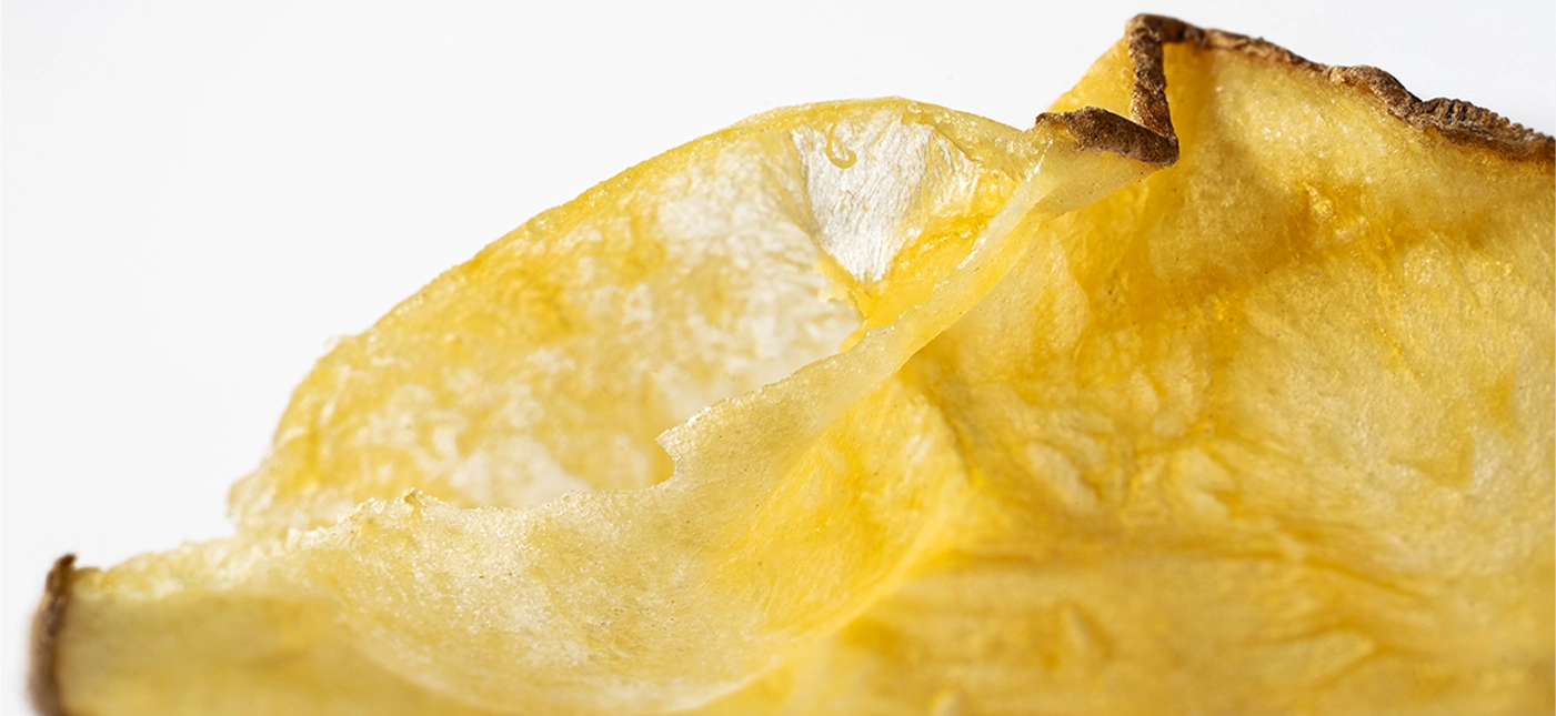 Macro close-up of a curled NÜKT crisp with a golden, blistered surface